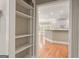 View from hallway, overlooking into the kitchen with white cabinetry and hardwood floors at 914 Champions Way, Mcdonough, GA 30252