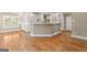Open-concept kitchen boasts white cabinets, hardwood floors, and large island counter at 914 Champions Way, Mcdonough, GA 30252