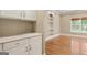 View of the wet bar area with a sink and built-in shelving and hardwood floors at 914 Champions Way, Mcdonough, GA 30252