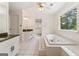 Bright bathroom with dual vanities, a large soaking tub, and white tile flooring at 107 Edgewater Way, Peachtree City, GA 30269