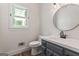 Updated powder room features modern sink, toilet, lighting, and round mirror at 107 Edgewater Way, Peachtree City, GA 30269