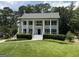 Stately two-story home featuring white siding, black shutters, a well-manicured lawn, and lush landscaping at 107 Edgewater Way, Peachtree City, GA 30269