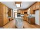 Traditional kitchen with island gas cooktop, wood cabinets, hardwood floors, and stainless steel appliances at 107 Edgewater Way, Peachtree City, GA 30269