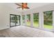 Bright sunroom with tiled floors, fan, sliding glass door, and several windows overlooking backyard at 107 Edgewater Way, Peachtree City, GA 30269