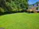 A big green backyard with a wooden deck next to the house at 424 Ivey Edwards Ln, Mcdonough, GA 30253