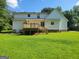 This backyard features a deck, green lawn, and a white house with a basketball hoop in the back at 424 Ivey Edwards Ln, Mcdonough, GA 30253