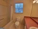Bathroom with a toilet, a bathtub with shower, a vanity, and a window at 424 Ivey Edwards Ln, Mcdonough, GA 30253