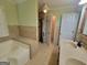 Bathroom showcasing a soaking tub, tiled shower, and convenient closet access at 424 Ivey Edwards Ln, Mcdonough, GA 30253