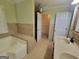 Bathroom showcasing a soaking tub, tiled shower, and convenient closet access at 424 Ivey Edwards Ln, Mcdonough, GA 30253