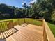This deck features wood flooring and wood railings in a backyard with a tree line in the distance at 424 Ivey Edwards Ln, Mcdonough, GA 30253