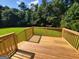 This deck features wood flooring and wood railings in a backyard with a tree line in the distance at 424 Ivey Edwards Ln, Mcdonough, GA 30253