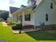 This exterior angle of the home displays green shutters, a green lawn, white siding, and a black roof at 424 Ivey Edwards Ln, Mcdonough, GA 30253