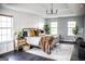 Bright bedroom with tray ceilings, a black metal bed frame, and decoratively styled with throw pillows and plants at 184 Fashion Xing, Mcdonough, GA 30252