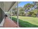 Covered back porch overlooks an expansive, grassy backyard surrounded by mature trees at 603 Rossie Court, Mcdonough, GA 30252