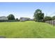 Large, grassy backyard features a detached storage building, privacy fence, and mature trees at 603 Rossie Court, Mcdonough, GA 30252