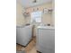Bright laundry room features a large window and storage shelves above washer and dryer at 603 Rossie Court, Mcdonough, GA 30252