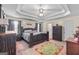 Spacious primary bedroom features a tray ceiling, carpet, and large bed with dark wood furniture at 603 Rossie Court, Mcdonough, GA 30252