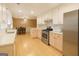 Bright kitchen with stainless appliances, light wood floors, and a view to the dining room at 45 Oak Wood Lane, Covington, GA 30016