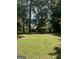 Expansive backyard view with lush green lawn and a glimpse of the house through the trees at 5277 Scofield Rd, South Fulton, GA 30349