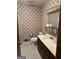 Bathroom with floral wallpaper, marble countertop vanity, and geometric patterned floors at 5277 Scofield Rd, South Fulton, GA 30349