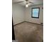 Simple bedroom with carpet, one window, and a ceiling fan with a light fixture at 5277 Scofield Rd, South Fulton, GA 30349