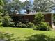 A brick two-story home with a deck, nestled in a large yard with mature trees at 5277 Scofield Rd, South Fulton, GA 30349