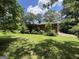 A brick two-story home with a deck, set in a large yard with mature trees at 5277 Scofield Rd, South Fulton, GA 30349