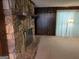 Living room displaying stacked stone fireplace, wood paneling, and carpet flooring at 5277 Scofield Rd, South Fulton, GA 30349