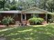 Classic red brick home with front porch, surrounded by mature trees and landscaped bushes at 5277 Scofield Rd, South Fulton, GA 30349