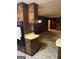 View of kitchen leading to the living area with stone fireplace and wood paneled walls at 5277 Scofield Rd, South Fulton, GA 30349