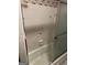 Tiled shower-tub combination with glass sliding doors and floral wallpaper in bathroom at 5277 Scofield Rd, South Fulton, GA 30349