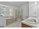 Bright bathroom features a double vanity, tiled floors, glass shower, and soaking tub at 100 Walnut Ct, Stockbridge, GA 30281