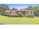 Charming single-story home featuring bay windows with red shutters and a lush front lawn at 100 Walnut Ct, Stockbridge, GA 30281