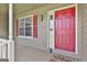 Inviting front porch with a vibrant red door, a window, and a welcoming doormat at 100 Walnut Ct, Stockbridge, GA 30281