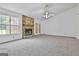 Spacious living room with a stone fireplace, neutral carpet, and natural light from the window at 100 Walnut Ct, Stockbridge, GA 30281