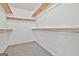 Organized walk-in closet with wood shelving and neutral carpet for functional storage at 100 Walnut Ct, Stockbridge, GA 30281