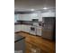Bright kitchen featuring white cabinets, stainless steel fridge, and wood flooring at 3211 Rockview Dr, Lithonia, GA 30038