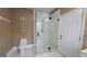 Bright bathroom equipped with a glass shower, toilet and white tiled floors at 1 Hemlock, Porterdale, GA 30014