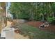 The backyard features a wooded view, a stone waterfall feature, and grass at 162 Watercress Ct, Stockbridge, GA 30281