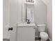 Well-lit half bathroom features a modern vanity with a white sink and updated fixtures at 162 Watercress Ct, Stockbridge, GA 30281