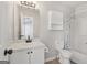 A bathroom featuring vanity, toilet, shower-tub combo and updated light fixture at 162 Watercress Ct, Stockbridge, GA 30281