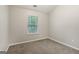 Compact bedroom features carpet flooring, a window, and neutral paint at 162 Watercress Ct, Stockbridge, GA 30281