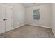 Bright bedroom with neutral walls, plush carpeting, closet, and natural light at 162 Watercress Ct, Stockbridge, GA 30281