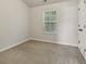 This neutral bedroom boasts a window bringing in natural light, carpet and a closet at 162 Watercress Ct, Stockbridge, GA 30281