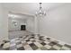 Elegant dining area with decorative checkered floors, modern chandelier, and an open view to the living room at 162 Watercress Ct, Stockbridge, GA 30281