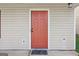 Close-up of a vibrant red front door with traditional panel design and beige siding at 162 Watercress Ct, Stockbridge, GA 30281