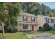 Charming two-story home with a well-maintained lawn, red shutters and door, and mature trees at 162 Watercress Ct, Stockbridge, GA 30281