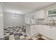 Open concept kitchen with white cabinets, granite countertops, and checkerboard flooring, with view to dining area at 162 Watercress Ct, Stockbridge, GA 30281