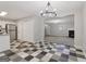 Open kitchen with checkerboard floors, white cabinets, stainless steel fridge flowing into living room at 162 Watercress Ct, Stockbridge, GA 30281