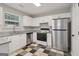 Modern kitchen featuring stainless steel appliances, granite countertops, and white cabinets at 162 Watercress Ct, Stockbridge, GA 30281